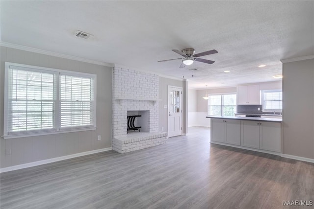 3740 Fieldcrest Dr, Montgomery, AL 36111 - unfurnished living room featuring ornamental molding, wood finished floors, ceiling fan, baseboards, and a fireplace