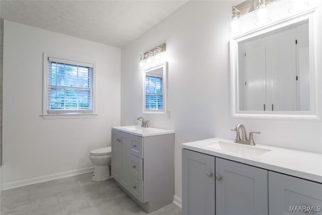 3740 Fieldcrest Dr, Montgomery, AL 36111 - full bathroom with two vanities, baseboards, toilet, tile patterned floors, and a textured ceiling