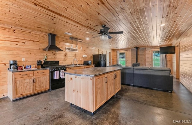 14291 Redland Rd, Tallassee, AL 36078 - kitchen featuring a wood stove, a kitchen island, wall chimney range hood, light brown cabinets, and black appliances