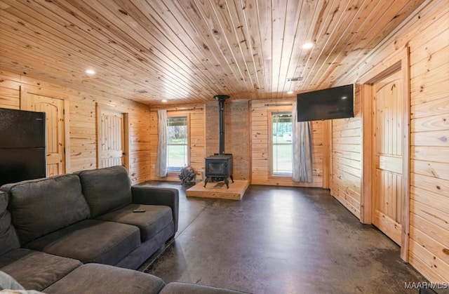 14291 Redland Rd, Tallassee, AL 36078 - living room with wooden ceiling, wooden walls, a wood stove, concrete flooring, and recessed lighting