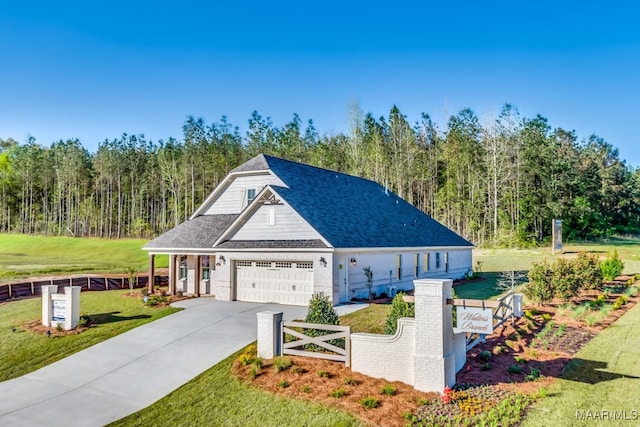 101 Ananias St, Troy, AL 36079 - view of front of house featuring a wooded view, fence, concrete driveway, a front yard, and a shingled roof
