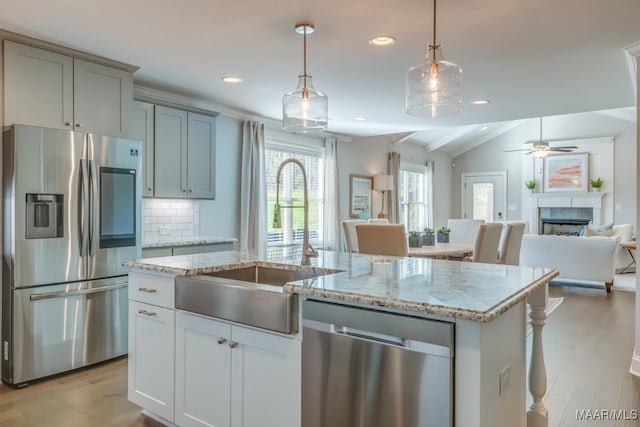 101 Ananias St, Troy, AL 36079 - kitchen featuring open floor plan, decorative backsplash, a sink, appliances with stainless steel finishes, and a fireplace