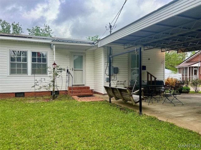 89 First Ave, Luverne, AL 36049 - rear view of property featuring entry steps, a lawn, crawl space, an attached carport, and a patio