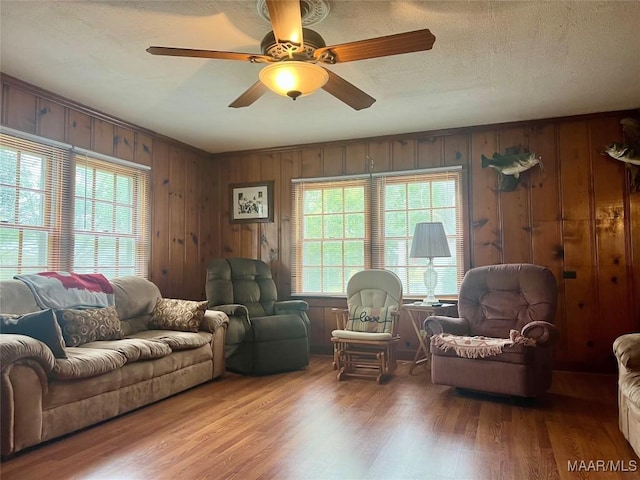 89 First Ave, Luverne, AL 36049 - living area with wood finished floors, healthy amount of natural light, a ceiling fan, wood walls, and a textured ceiling