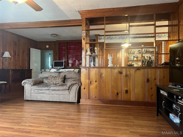 89 First Ave, Luverne, AL 36049 - living room featuring wooden walls, light wood-style flooring, a textured ceiling, and ceiling fan