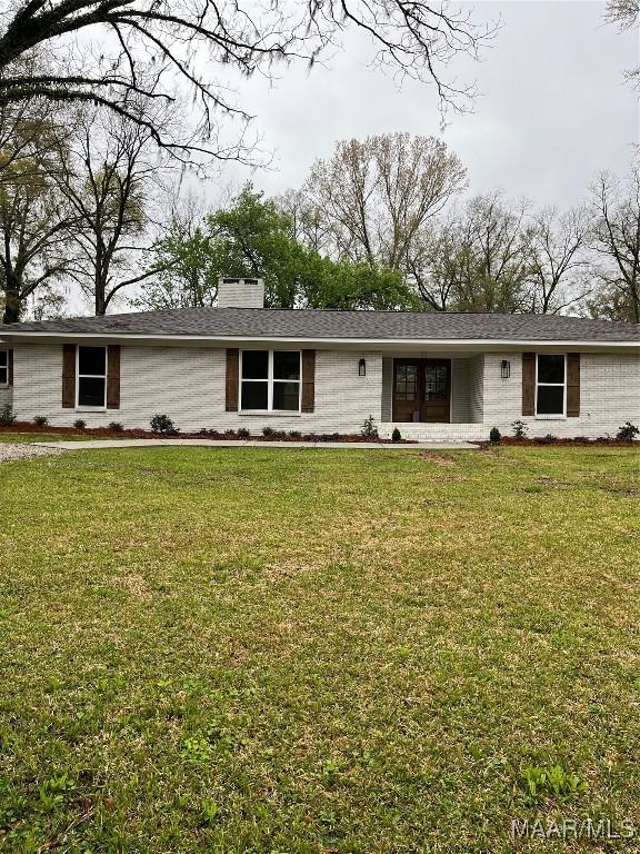 267 County Road 65th Rd, Valley Grande, AL 36701 - view of front of house with a chimney, a front yard, and brick siding