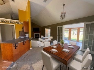dining area featuring lofted ceiling, visible vents, and a fireplace