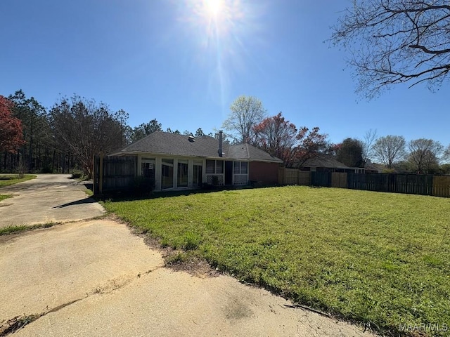 view of front of house with driveway, fence, and a front yard