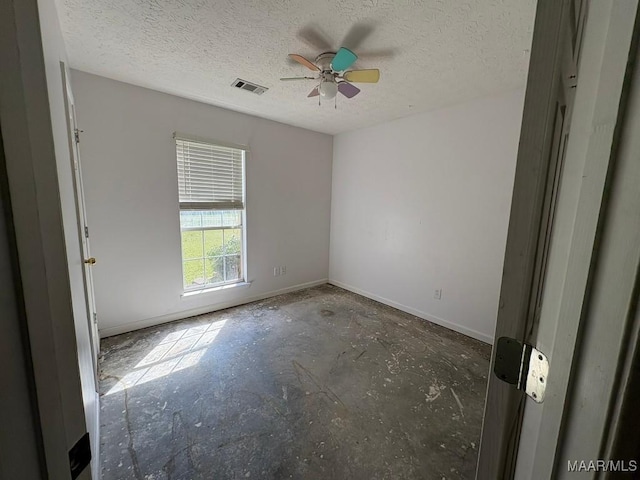 empty room featuring baseboards, visible vents, a ceiling fan, and a textured ceiling