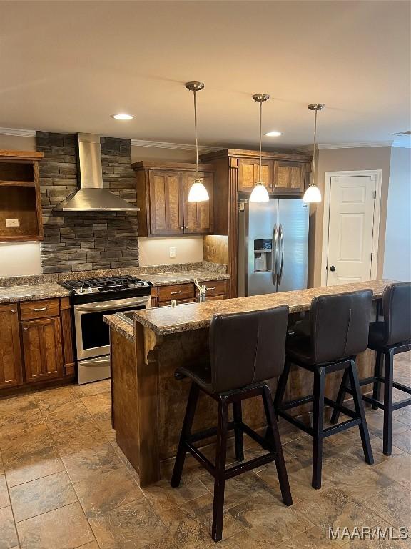376 Mckenzie St, Mckenzie, AL 36456 - kitchen featuring ornamental molding, wall chimney exhaust hood, a kitchen breakfast bar, and appliances with stainless steel finishes