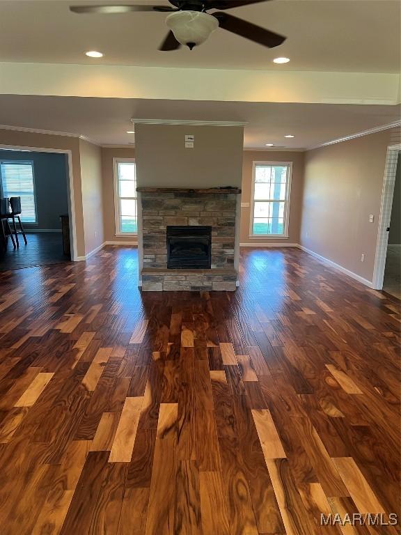 376 Mckenzie St, Mckenzie, AL 36456 - unfurnished living room featuring baseboards, ornamental molding, wood finished floors, a ceiling fan, and a stone fireplace
