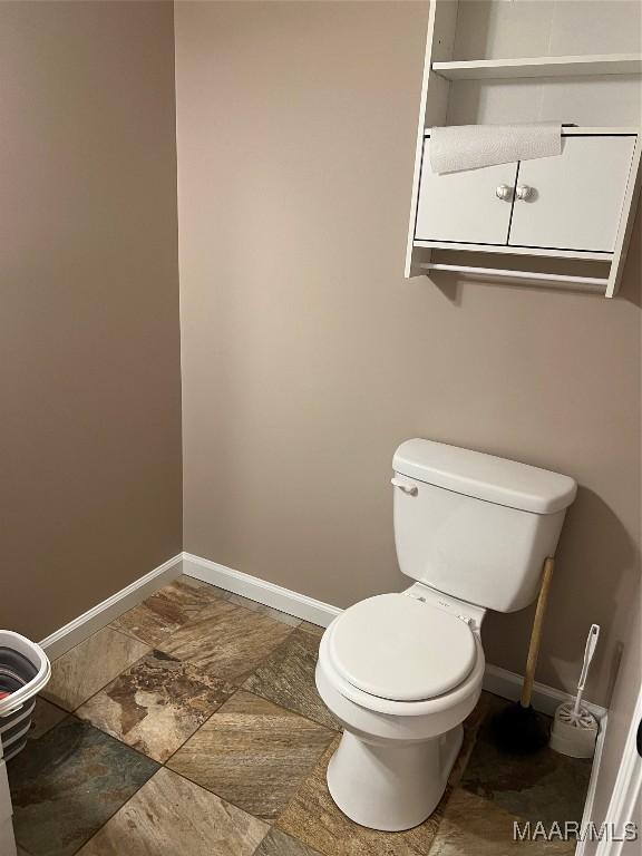376 Mckenzie St, Mckenzie, AL 36456 - bathroom with toilet, stone finish floor, and baseboards