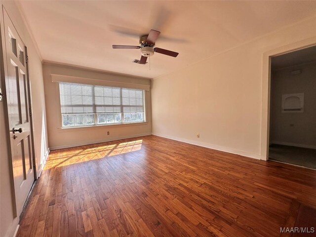 empty room with dark wood-style floors, ceiling fan, and baseboards