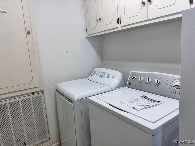clothes washing area with washing machine and clothes dryer and cabinet space