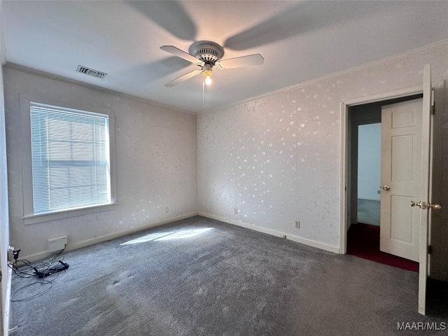 unfurnished bedroom with baseboards, visible vents, crown molding, and carpet