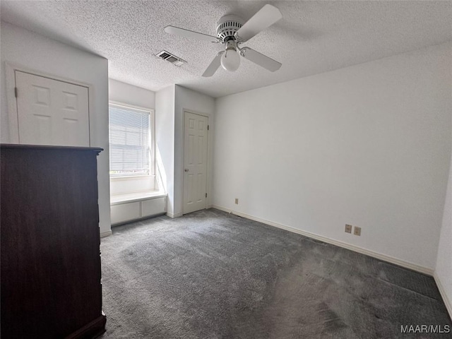 unfurnished bedroom with baseboards, a textured ceiling, carpet floors, ceiling fan, and visible vents