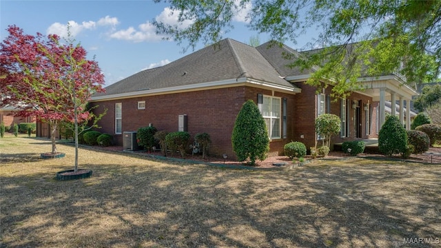 1580 W Overbrook Rd, Millbrook, AL 36054 - view of home's exterior featuring central AC unit, roof with shingles, brick siding, and a lawn