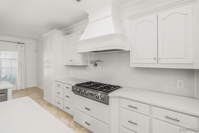 1580 W Overbrook Rd, Millbrook, AL 36054 - kitchen featuring stainless steel gas stovetop, light countertops, white cabinets, baseboards, and custom range hood