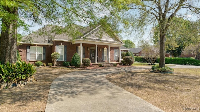 1580 W Overbrook Rd, Millbrook, AL 36054 - view of front facade featuring a porch, brick siding, and curved driveway