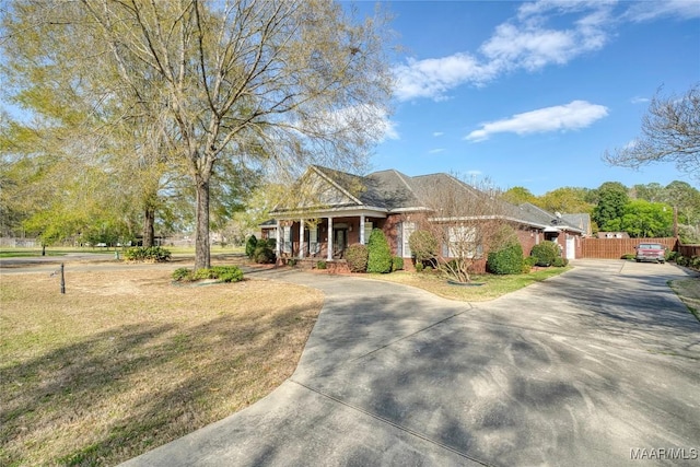 1580 W Overbrook Rd, Millbrook, AL 36054 - view of front of property with driveway, fence, covered porch, an attached garage, and a front yard