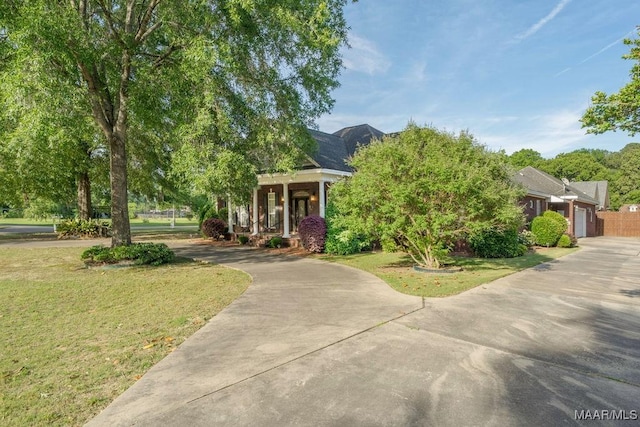 1580 W Overbrook Rd, Millbrook, AL 36054 - view of front facade featuring concrete driveway, a front yard, and covered porch