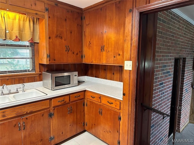 125 Butler St, Selma, AL 36701 - kitchen with stainless steel microwave, a sink, brown cabinets, and light countertops