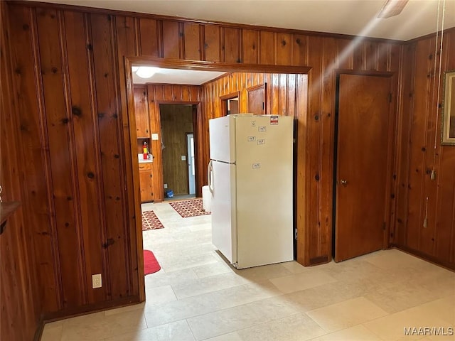 125 Butler St, Selma, AL 36701 - kitchen featuring wood walls, light floors, brown cabinetry, and freestanding refrigerator