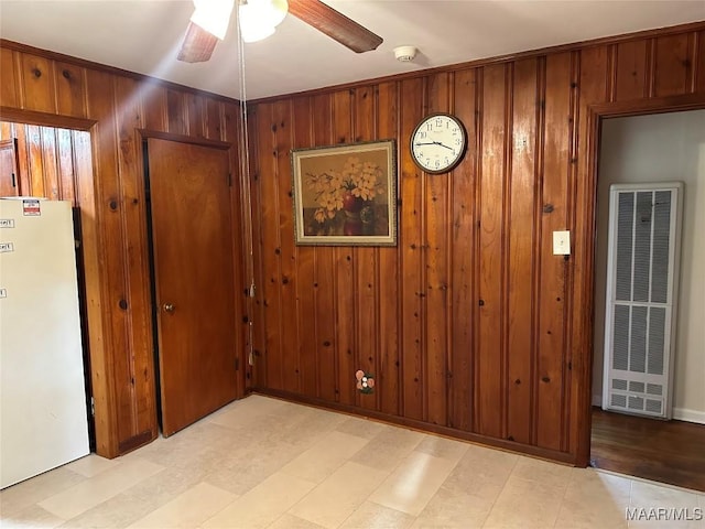 125 Butler St, Selma, AL 36701 - interior space with a heating unit, ceiling fan, wood walls, freestanding refrigerator, and light floors
