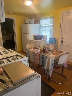 kitchen with white cabinets, white appliances, and wood finished floors