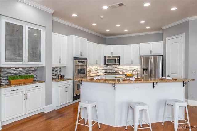 9533 Fendall Hall Cir, Montgomery, AL 36117 - kitchen with dark wood-style floors, a breakfast bar area, visible vents, and stainless steel appliances