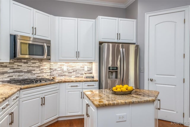 9533 Fendall Hall Cir, Montgomery, AL 36117 - kitchen featuring crown molding, stainless steel appliances, tasteful backsplash, white cabinetry, and a center island