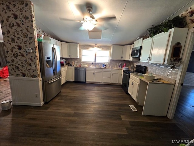 kitchen with white cabinetry, a sink, stainless steel appliances, and dark wood finished floors