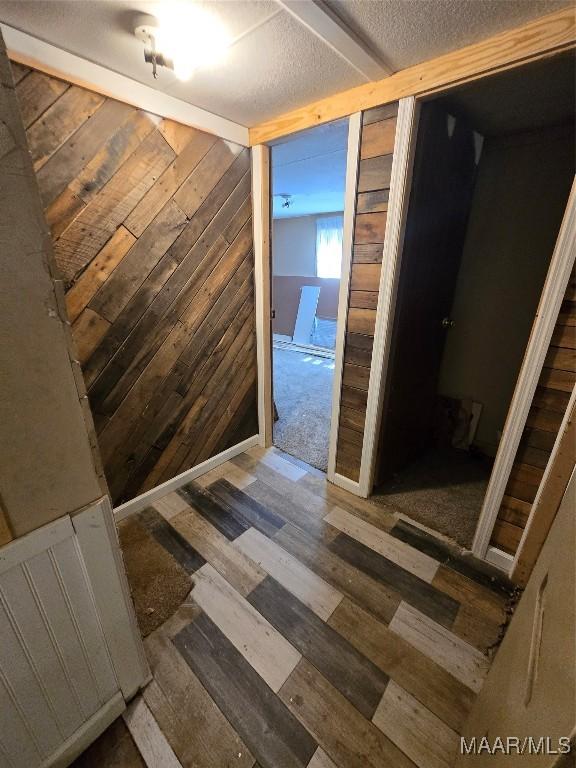 9100 Grier Rd, Wetumpka, AL 36092 - hall featuring wood finished floors, wooden walls, and a textured ceiling