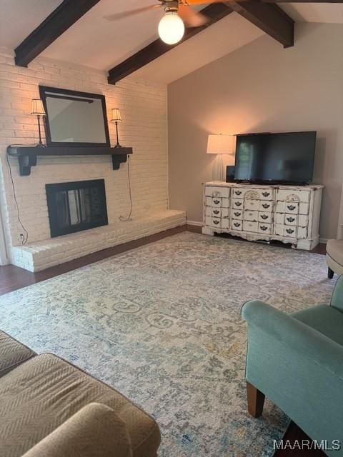 living area with beam ceiling, baseboards, a fireplace, and ceiling fan