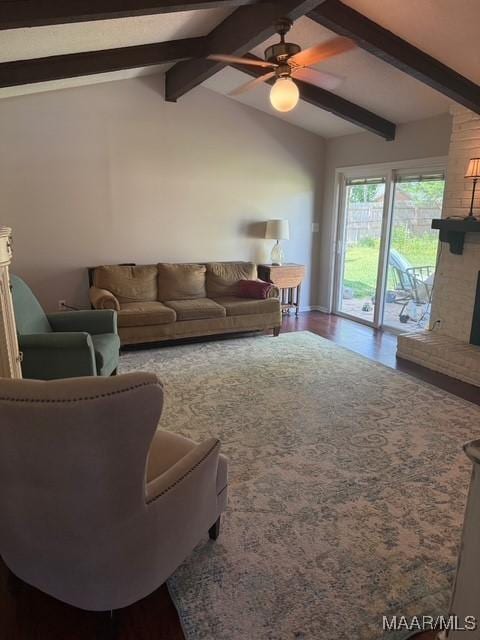 living room with dark wood-type flooring, a fireplace, a ceiling fan, and vaulted ceiling with beams