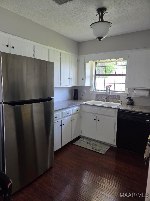 kitchen featuring a sink, freestanding refrigerator, black dishwasher, and white cabinets