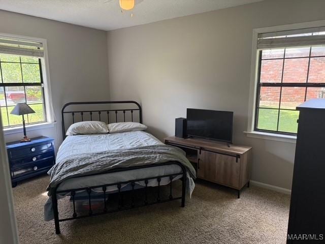 carpeted bedroom featuring baseboards and a ceiling fan