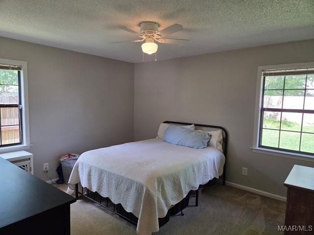 bedroom featuring a textured ceiling, carpet floors, a ceiling fan, and baseboards