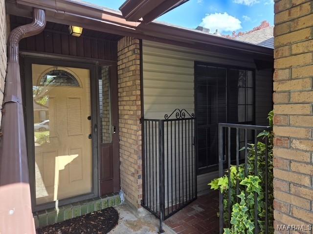 doorway to property featuring brick siding