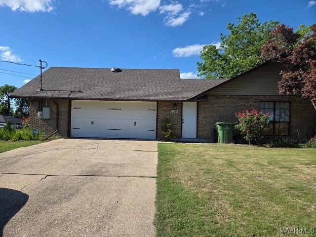 ranch-style house featuring concrete driveway, a front yard, brick siding, and an attached garage