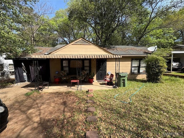 rear view of house with a yard and a patio area