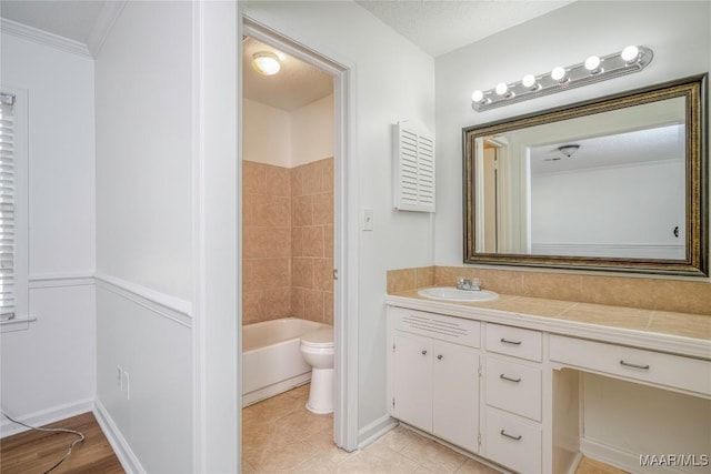 bathroom with baseboards, toilet, vanity, and tile patterned floors
