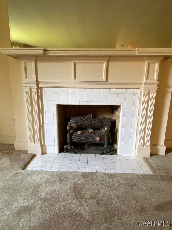 room details featuring a tiled fireplace and carpet floors