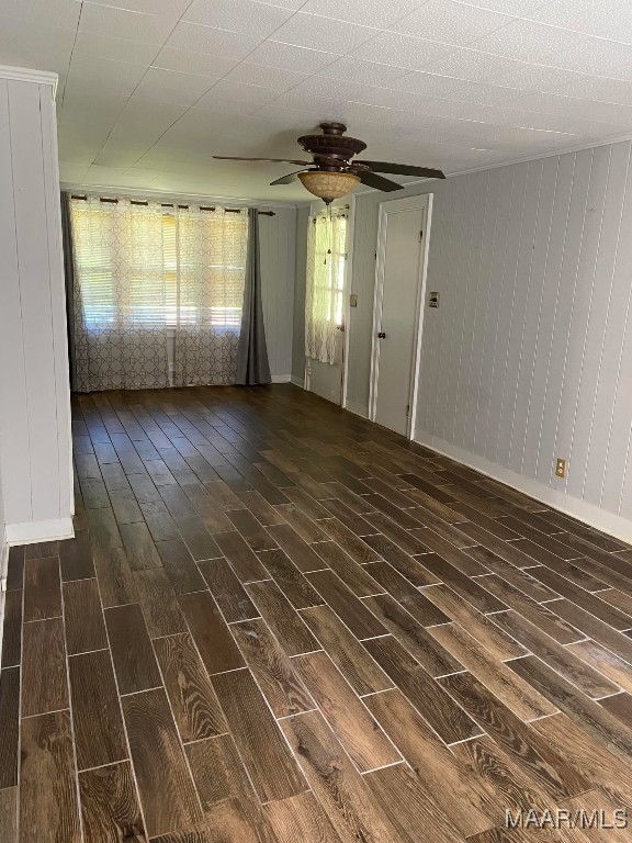 interior space featuring ceiling fan, baseboards, and dark wood-style flooring