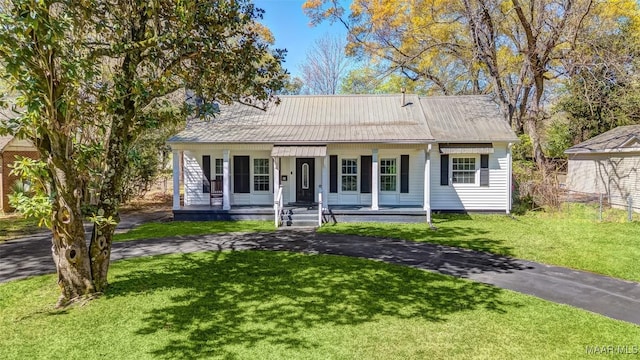 view of front of house with a porch, a front lawn, and metal roof