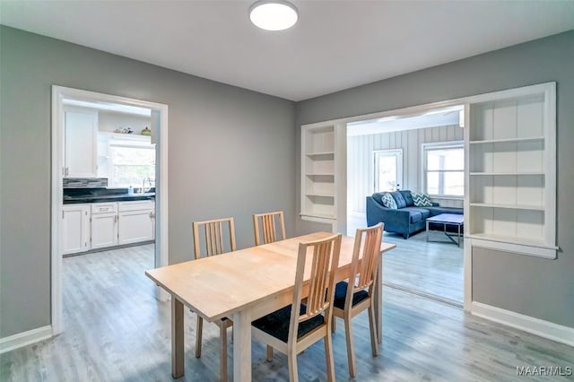 dining space featuring baseboards and light wood finished floors