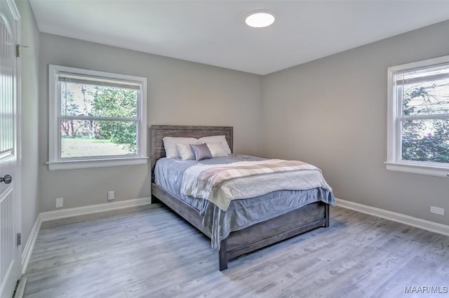 bedroom featuring baseboards and light wood finished floors