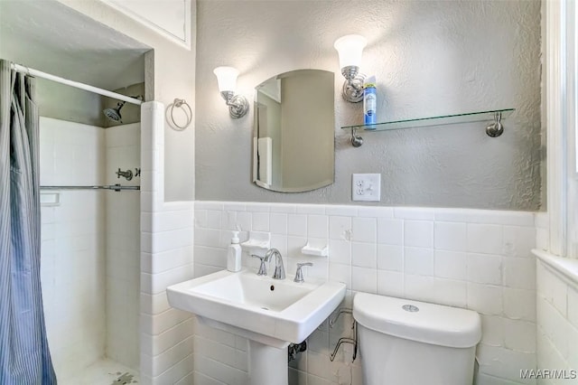 full bath featuring a shower stall, tile walls, toilet, and a textured wall