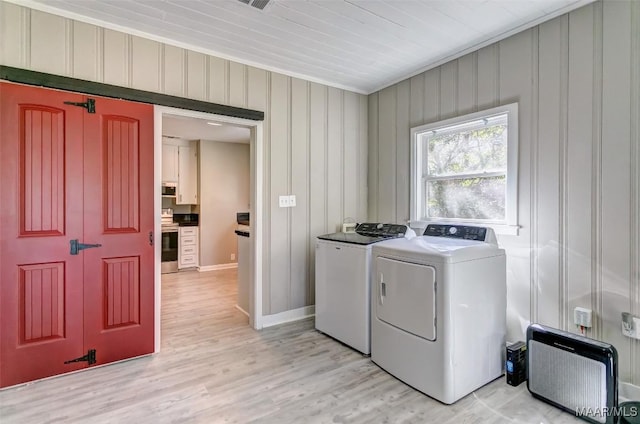 washroom featuring baseboards, laundry area, crown molding, washing machine and clothes dryer, and light wood-style flooring
