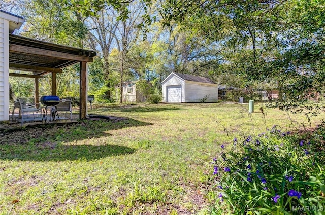 view of yard featuring an outbuilding, a shed, a detached garage, and fence